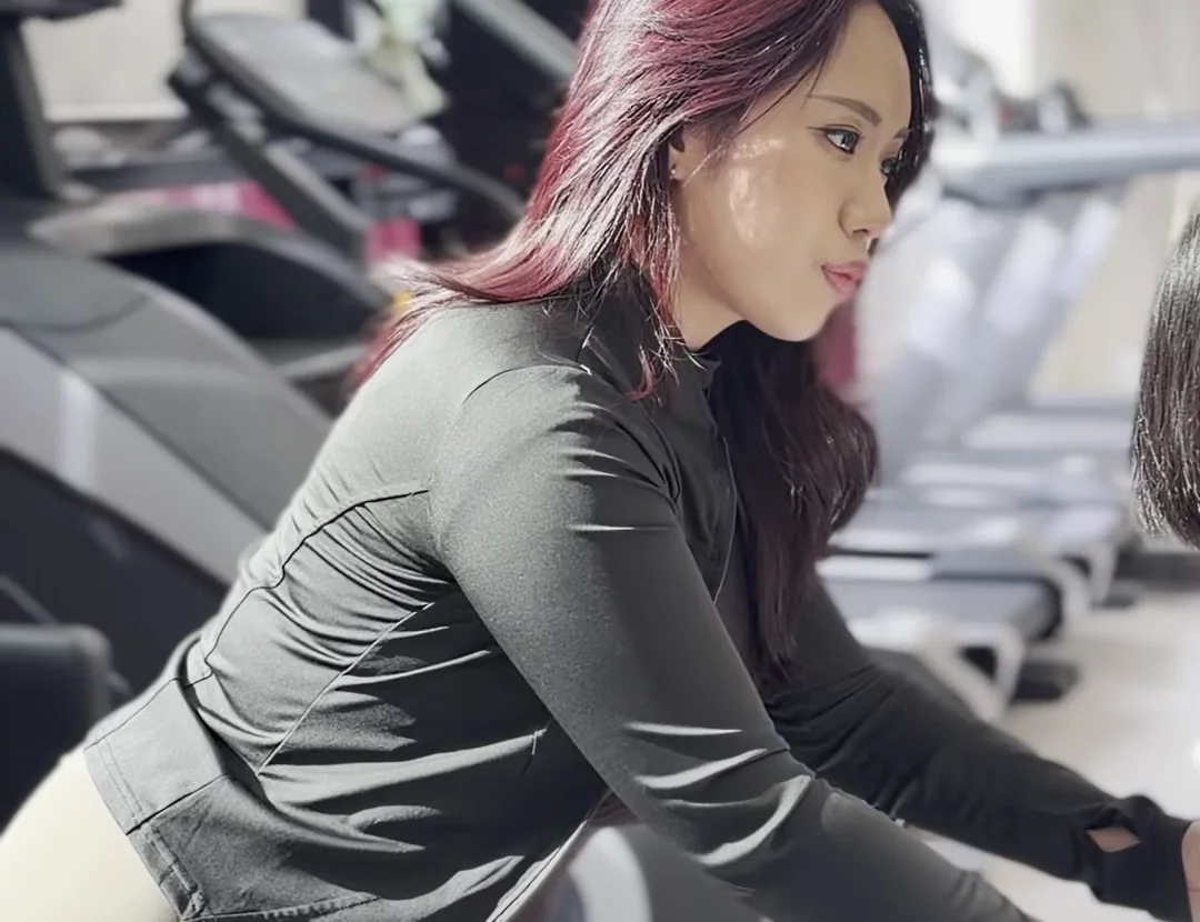 여성 강사가 회원의 자세와 정렬을 확인하며 운동을 지도하는 모습